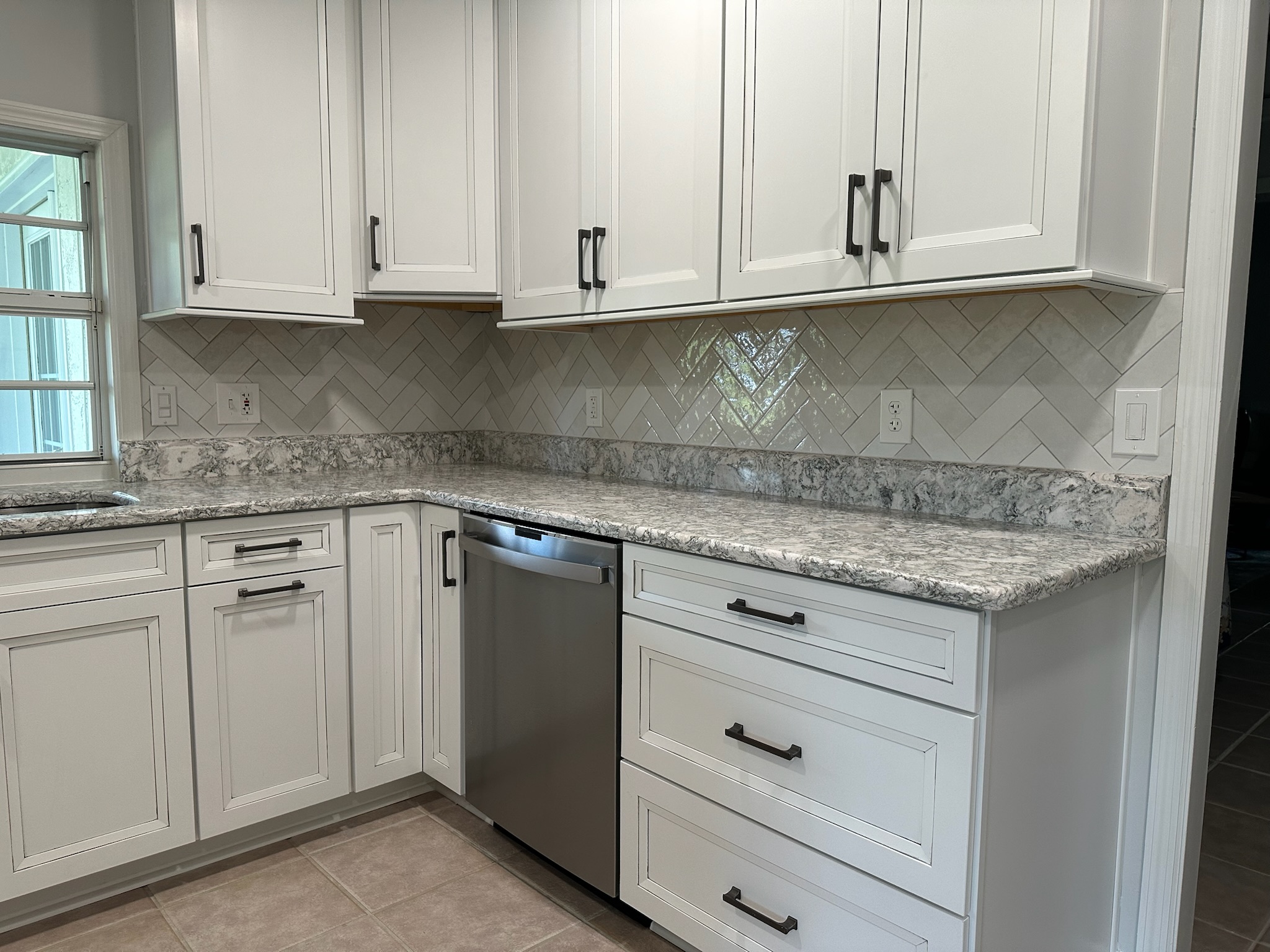 Gray Herringbone Backsplash with White Cabinets.