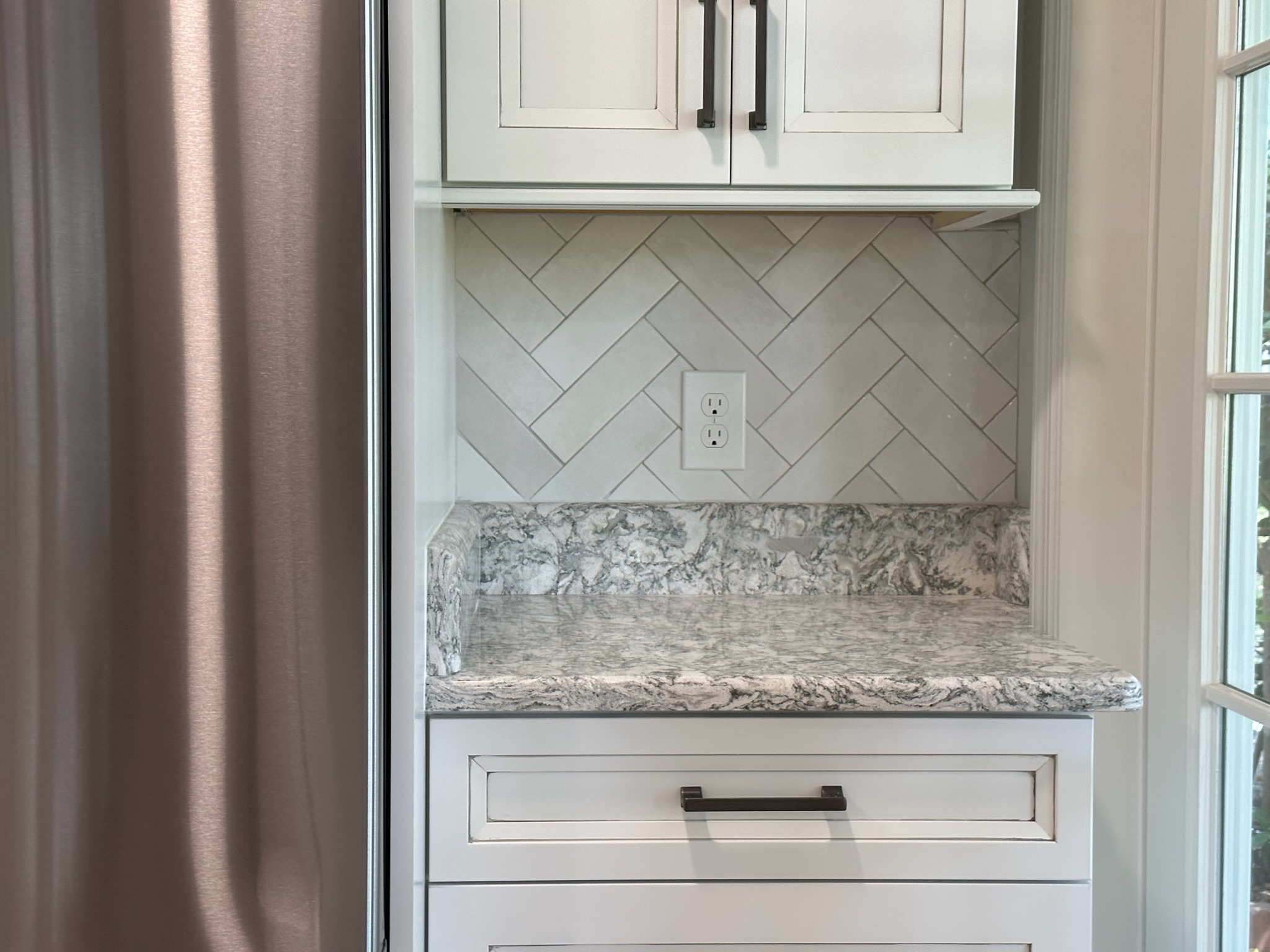 Gray Herringbone Backsplash with White Cabinets.