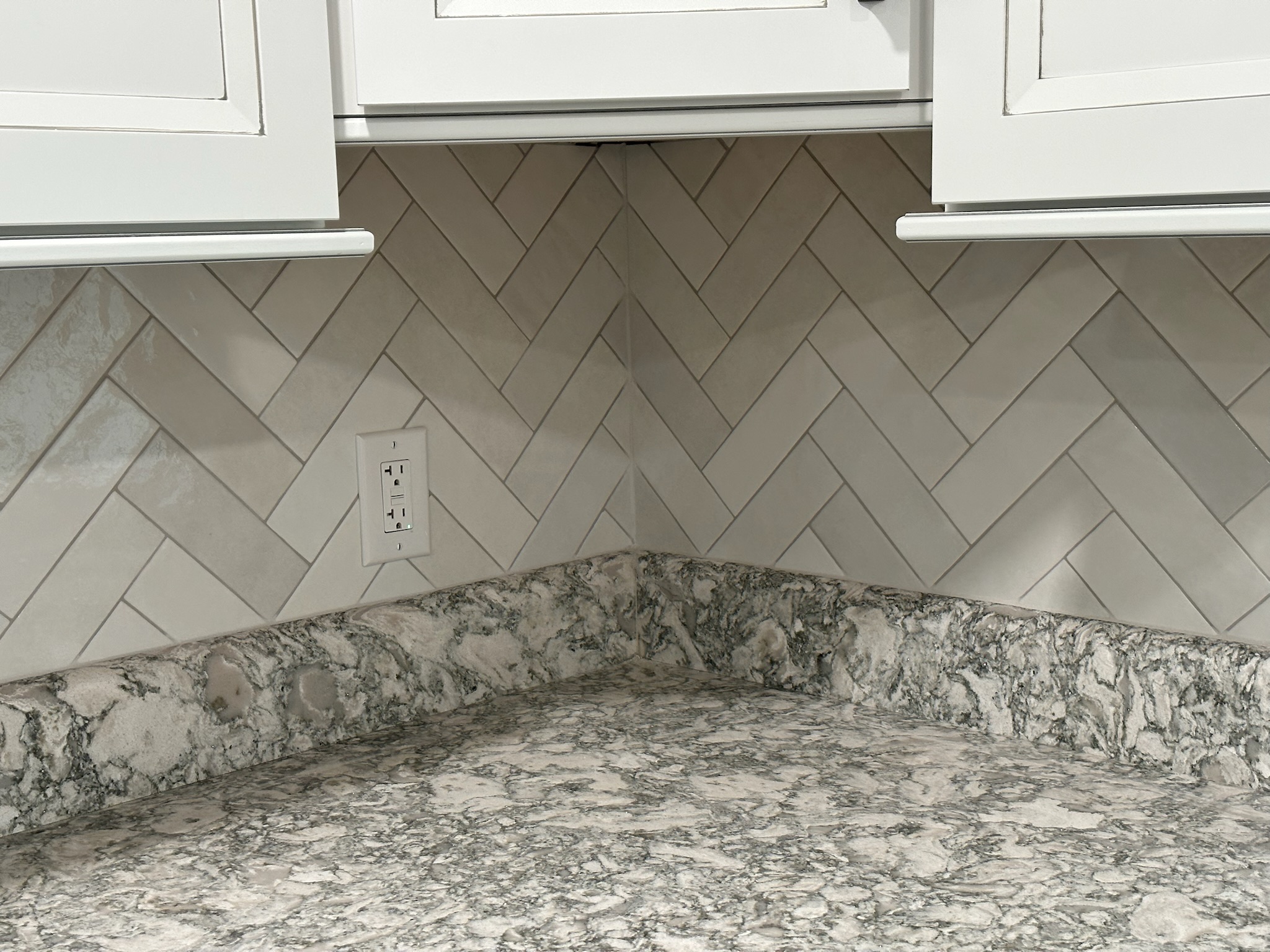 Gray Herringbone Backsplash with White Cabinets.