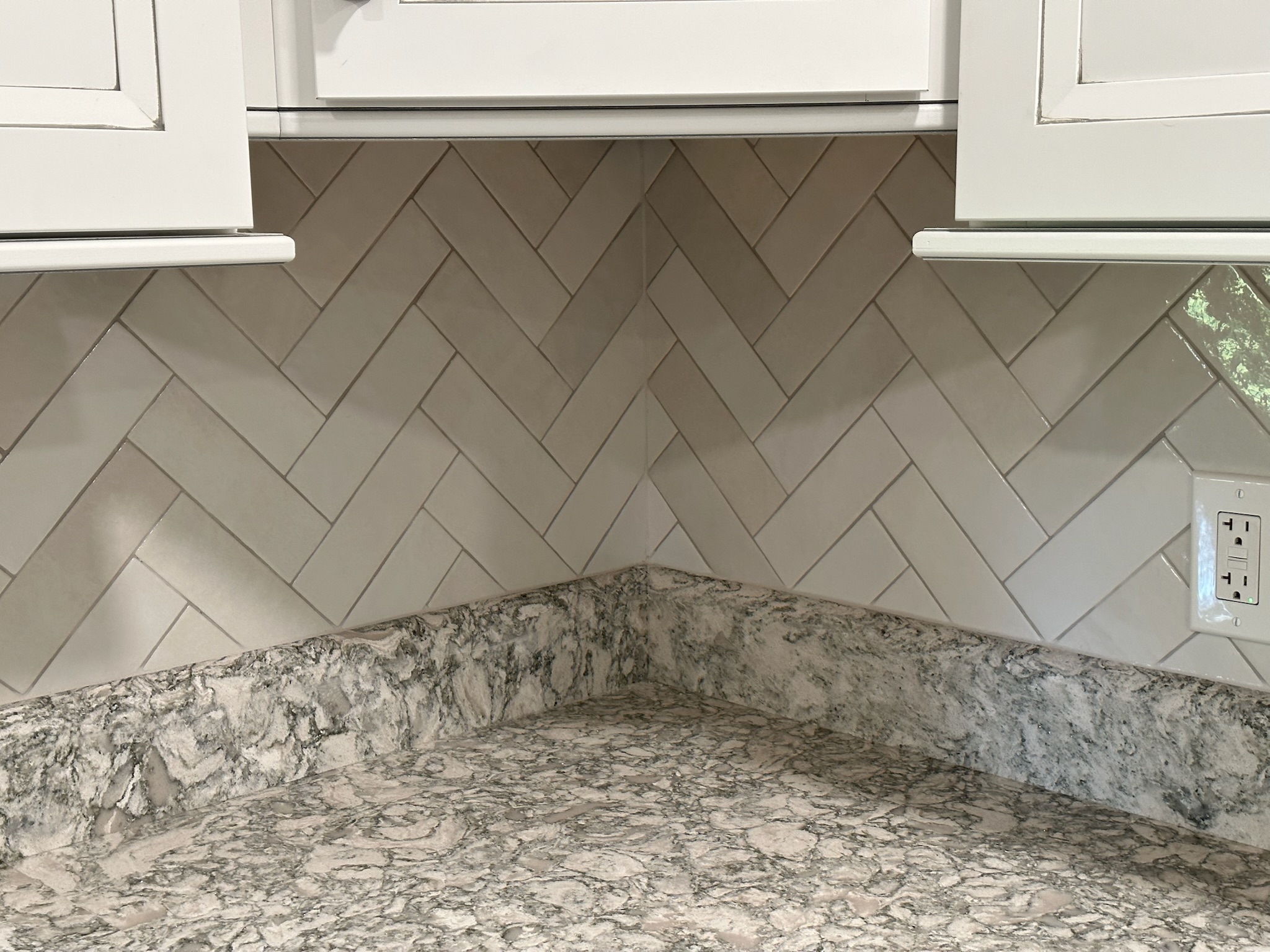Gray Herringbone Backsplash with White Cabinets.