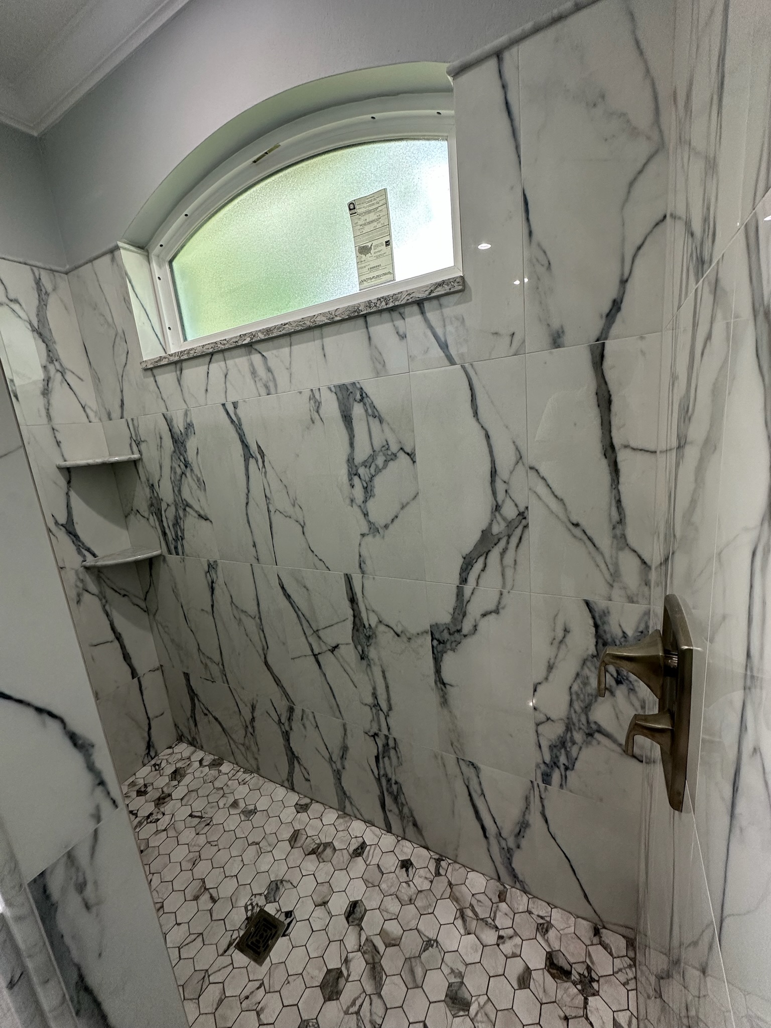 Marble Shower Framed by an Arched Window.
