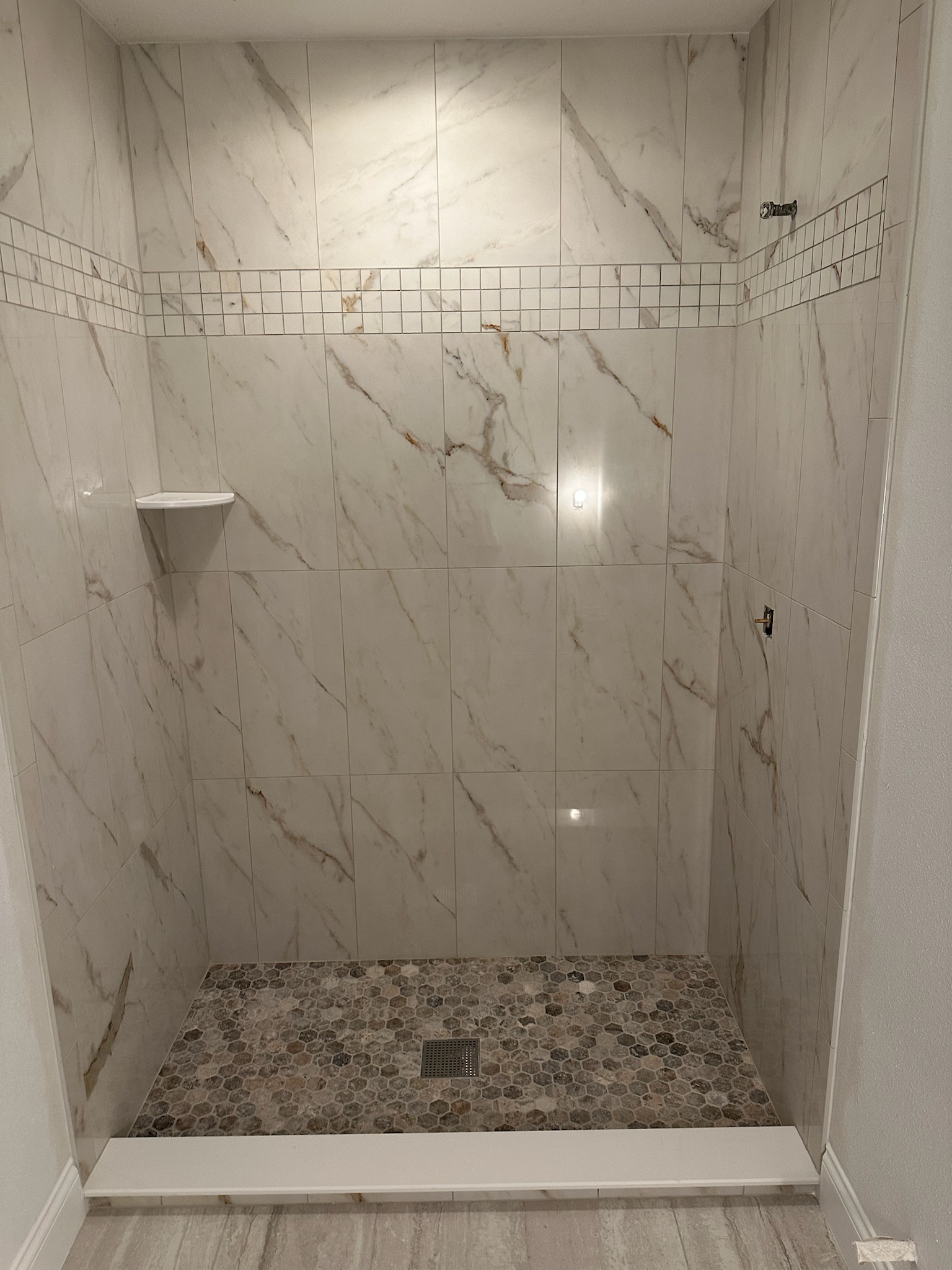 Marble Shower with a Mosaic Accent Stripe.