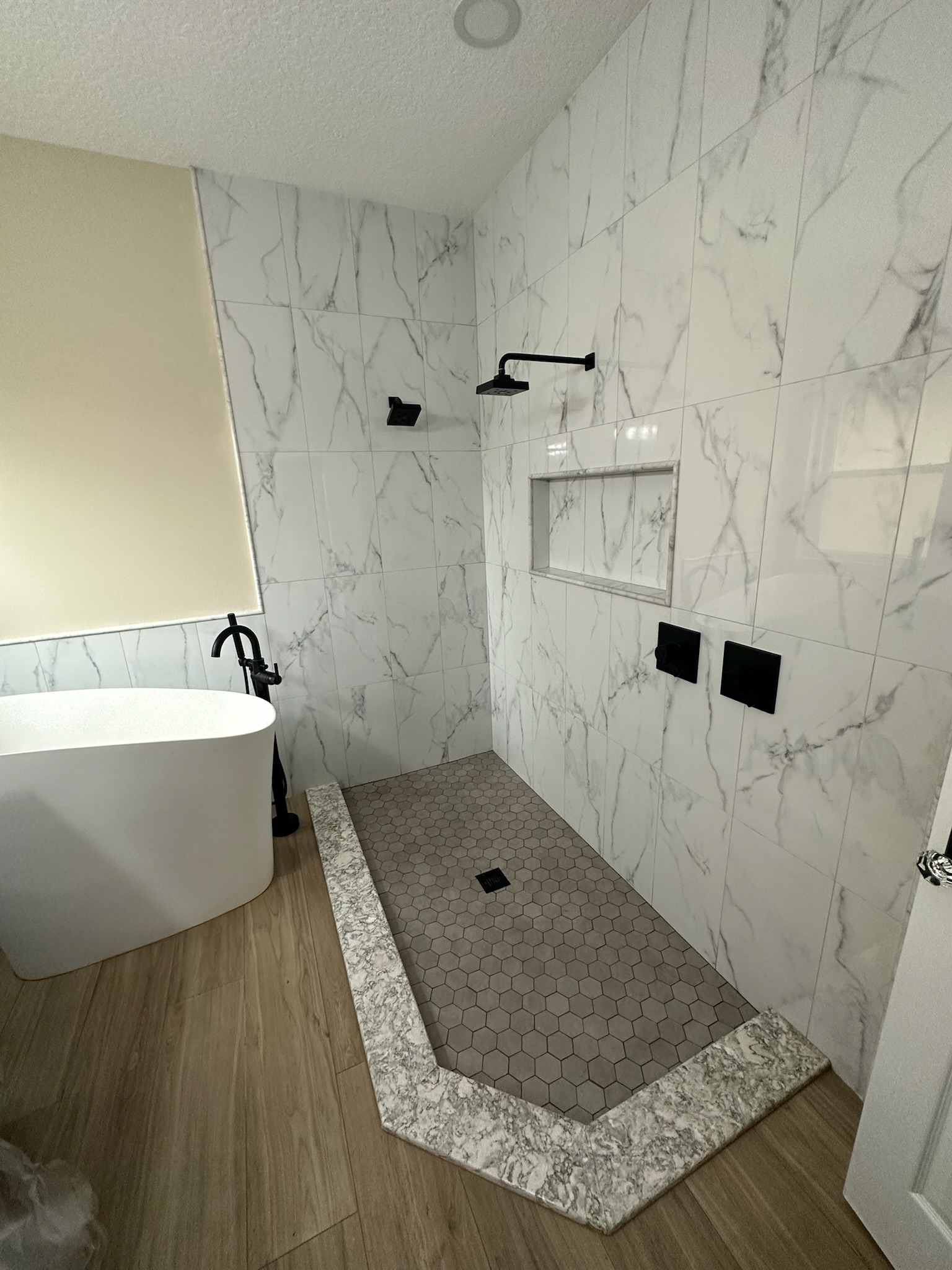 Large-Format Marble Shower with a Recessed Niche.