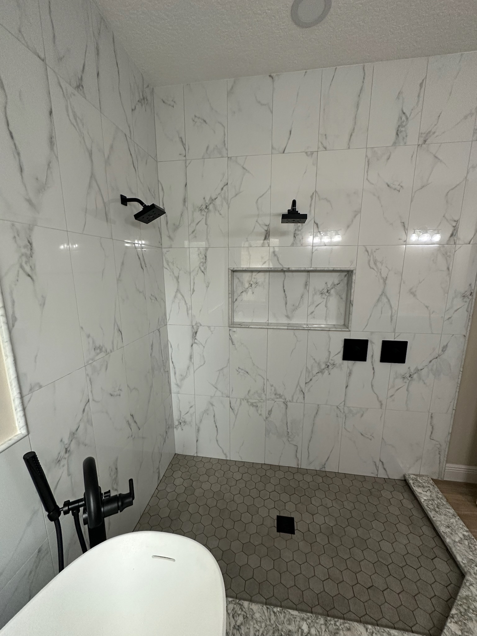 Large-Format Marble Shower with a Recessed Niche.