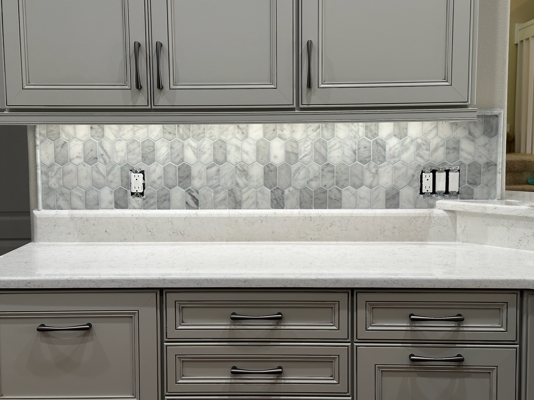 Gray Kitchen Cabinets with a Mosaic Tile Backsplash.