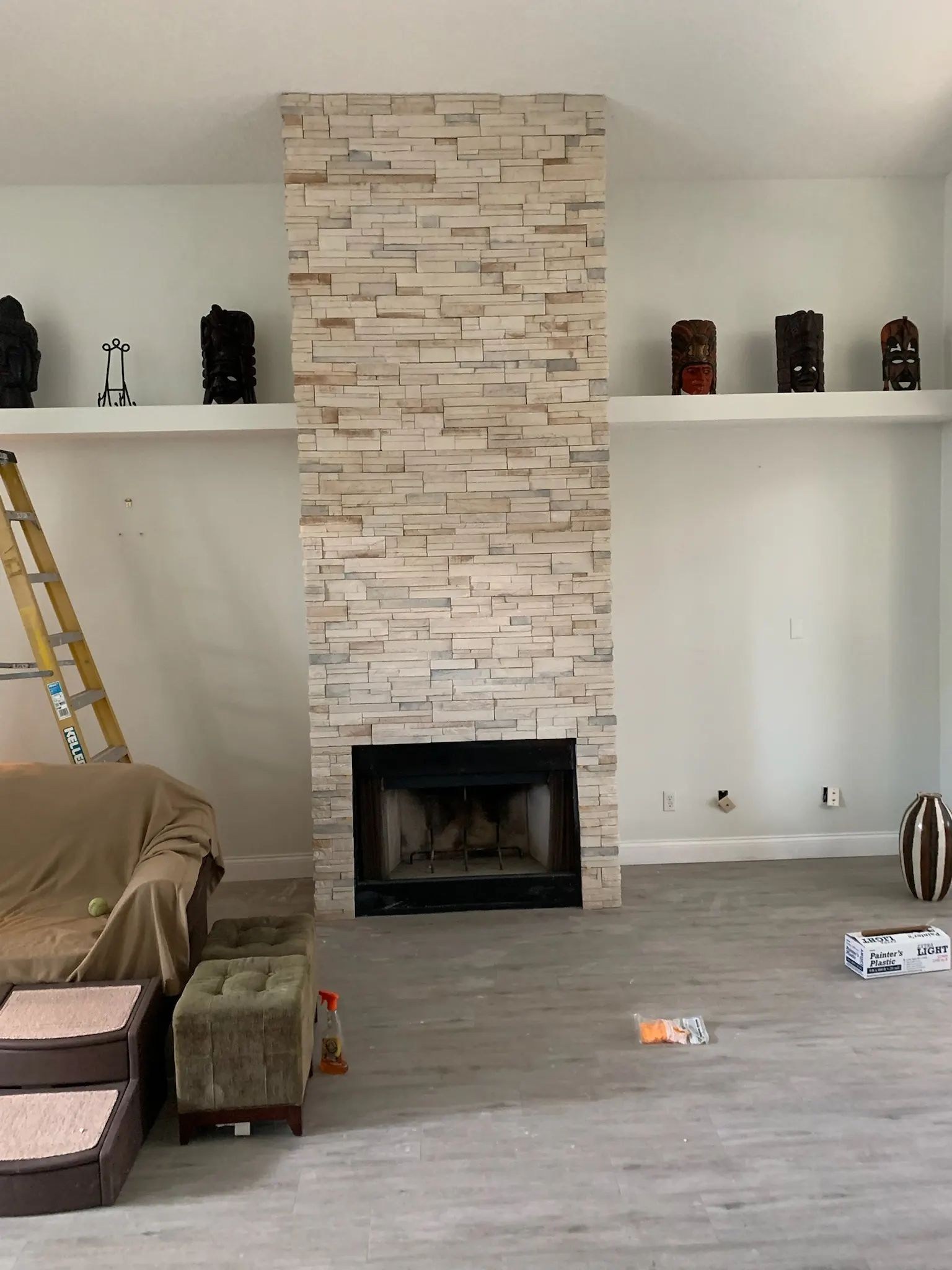 Living room fireplace with full-height stacked stone veneer between built-in wall sections.