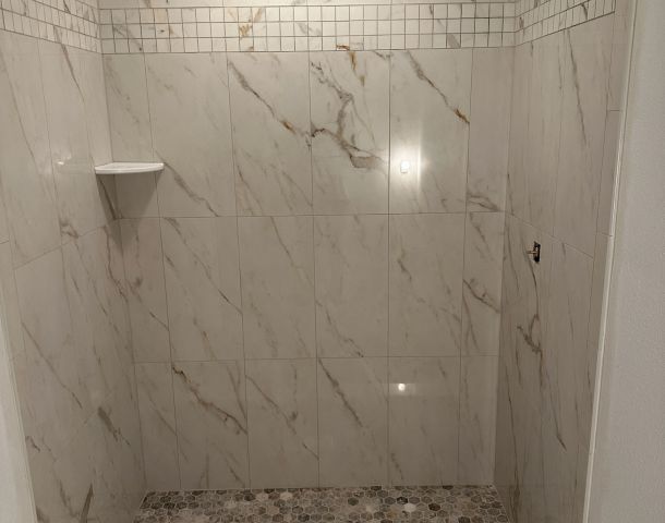 Marble Shower with a Mosaic Accent Stripe.