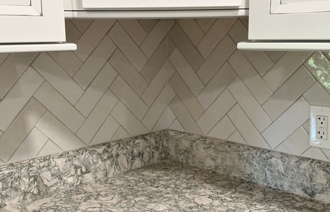 Gray Herringbone Backsplash with White Cabinets.